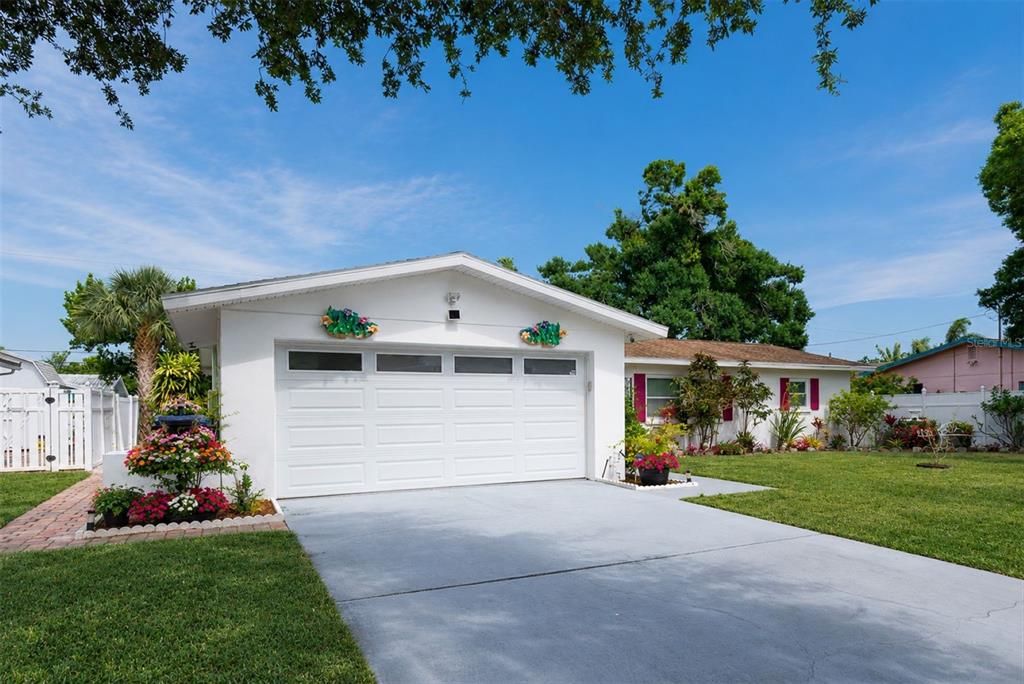A single-story white house with a garage, red shutters, and a front lawn — 6212 20TH STREET S, ST PETERSBURG, FL