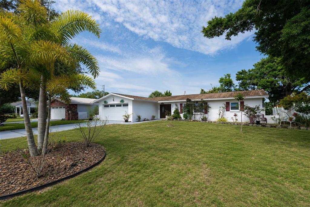 A single-story house with a white exterior, a two-car garage, and a front lawn at sunset — 6212 20TH STREET S, ST PETERSBURG, FL