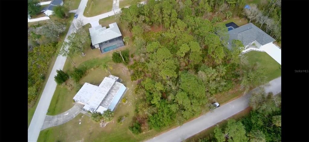 An aerial view shows three houses surrounded by trees and vegetation near two paved roads — 23350 BUCKNER AVENUE, PUNTA GORDA, FL