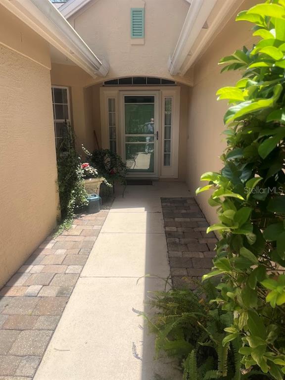 A paved walkway leads to a front door with a screen door and side windows — 16 LAFAYETTE LANE, PALM COAST, FL