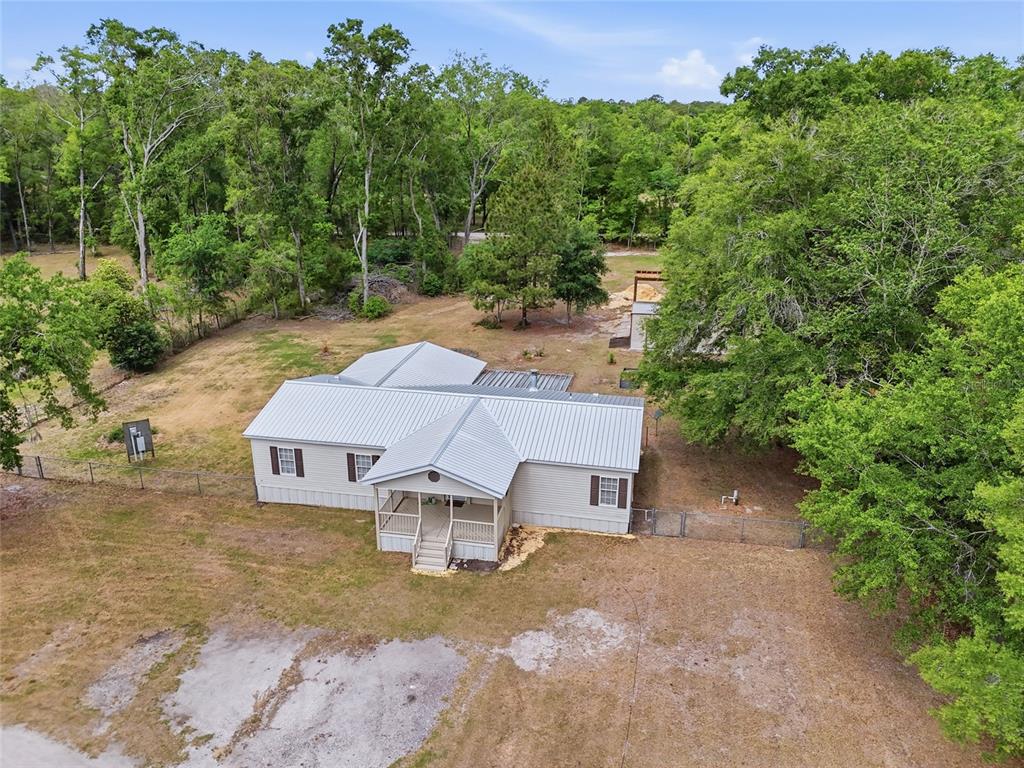 An aerial view shows a single-story house with a metal roof and a front porch — 9528 NW 235TH TERRACE, ALACHUA, FL