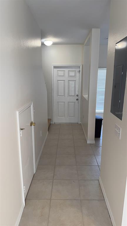A tiled entryway features a white front door, a small closet, and a wall-mounted electrical panel — 8511 TRAIL WIND DRIVE, TAMPA, FL