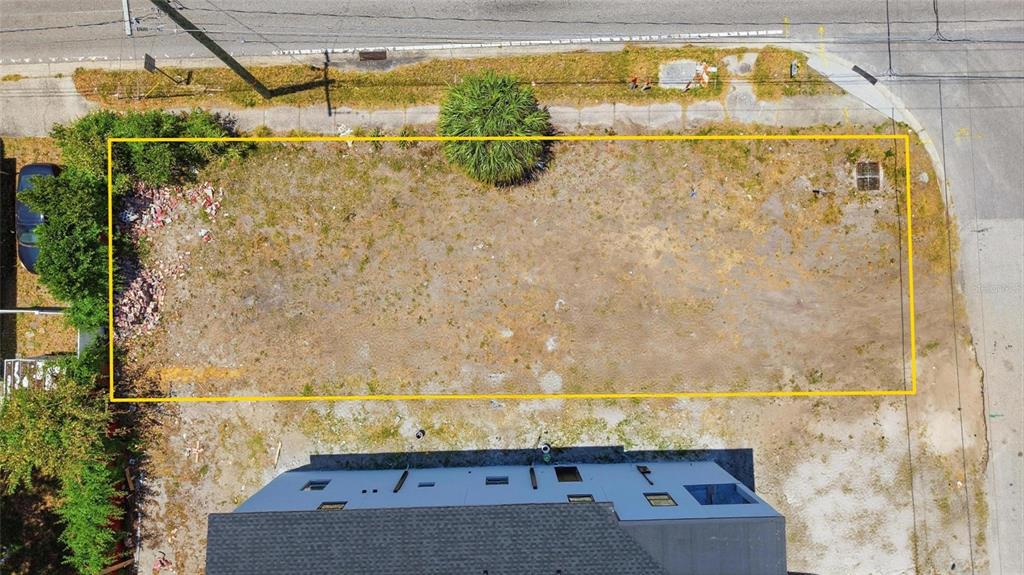 An aerial view shows a rectangular vacant lot outlined in yellow next to a building — 4124 W NASSAU STREET, TAMPA, FL
