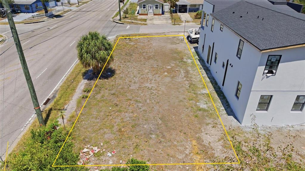 An aerial view shows a vacant rectangular lot outlined in yellow next to a building — 4124 W NASSAU STREET, TAMPA, FL