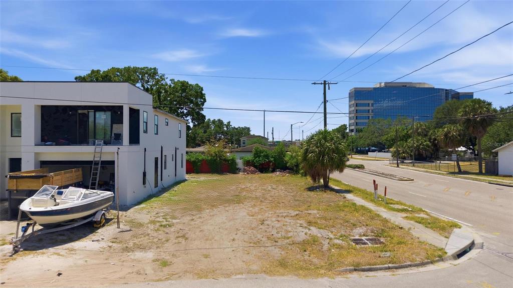 A vacant lot sits next to a modern white building with a boat parked outside — 4124 W NASSAU STREET, TAMPA, FL