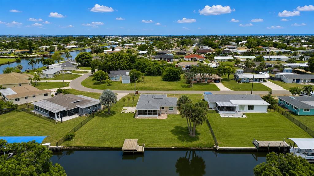 An aerial view of waterfront houses with private docks along a canal in a neighborhood — 132 CONCORD DRIVE NE, PORT CHARLOTTE, FL