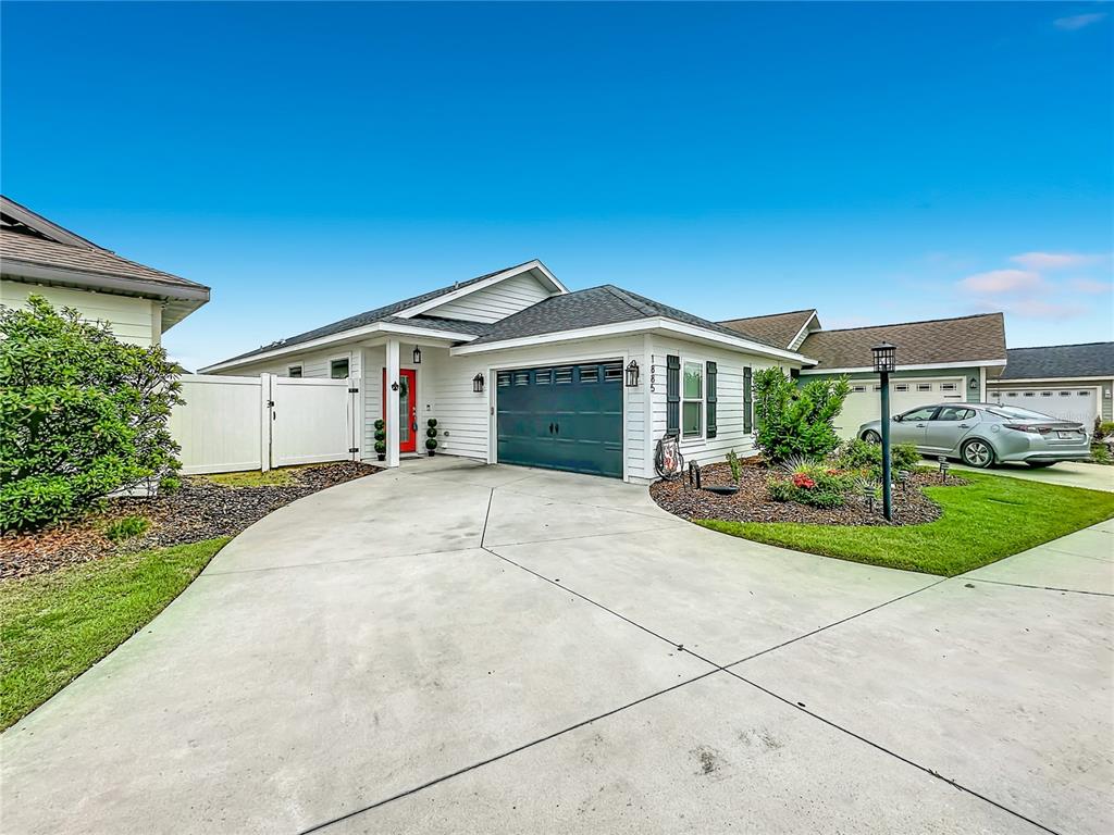 A three-story building with green siding and a stone facade features a second-story balcony — 1885 SW 245TH TERRACE, NEWBERRY, FL