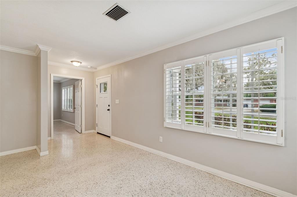 A room with light gray walls, terrazzo flooring, and white plantation shutters on the windows — 308 BRENTWOOD DRIVE, TEMPLE TERRACE, FL