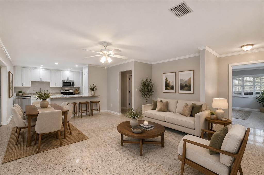 An open-concept living and dining area features white cabinets, a kitchen island, and neutral furniture — 308 BRENTWOOD DRIVE, TEMPLE TERRACE, FL