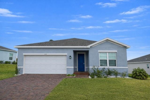 A single-story blue house with a white garage door and a blue front door — 6740 Rumine Circle, Vero Beach FL 32967, VERO BEACH, FL