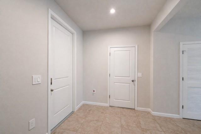 An interior view showing three white doors, light-colored walls, and tan tile flooring — 6740 Rumine Circle, Vero Beach FL 32967, VERO BEACH, FL