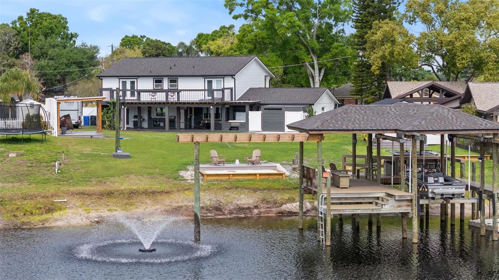 A two-story house with a backyard, a wooden deck, a boat dock, and a water fountain — 10525 HOMESTEAD DRIVE, TAMPA, FL