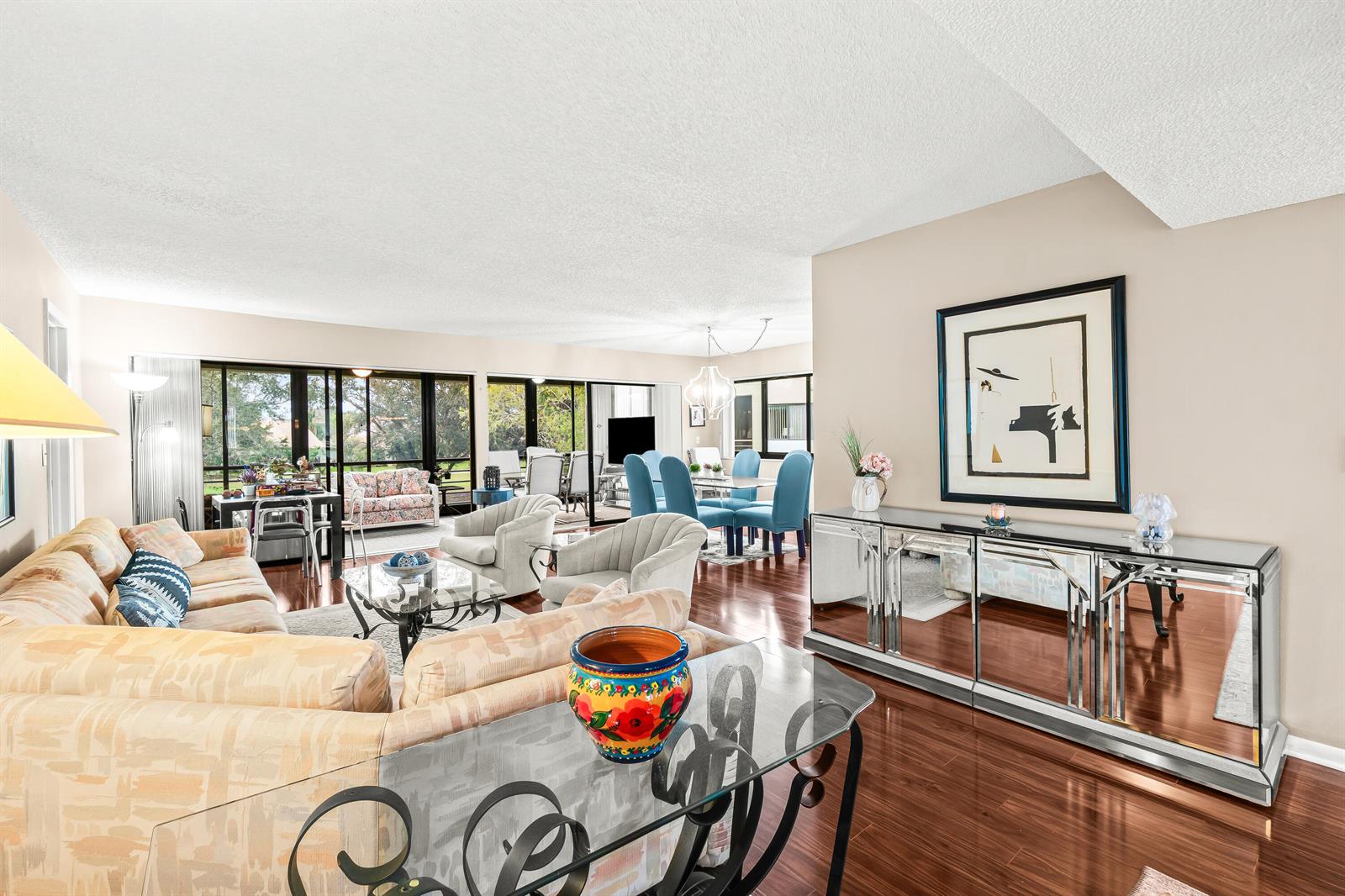 A living and dining area features hardwood floors, a mirrored sideboard, and large sliding glass doors — 5687 Fairway Park Drive, Boynton Beach FL 33437, BOYNTON BEACH, FL