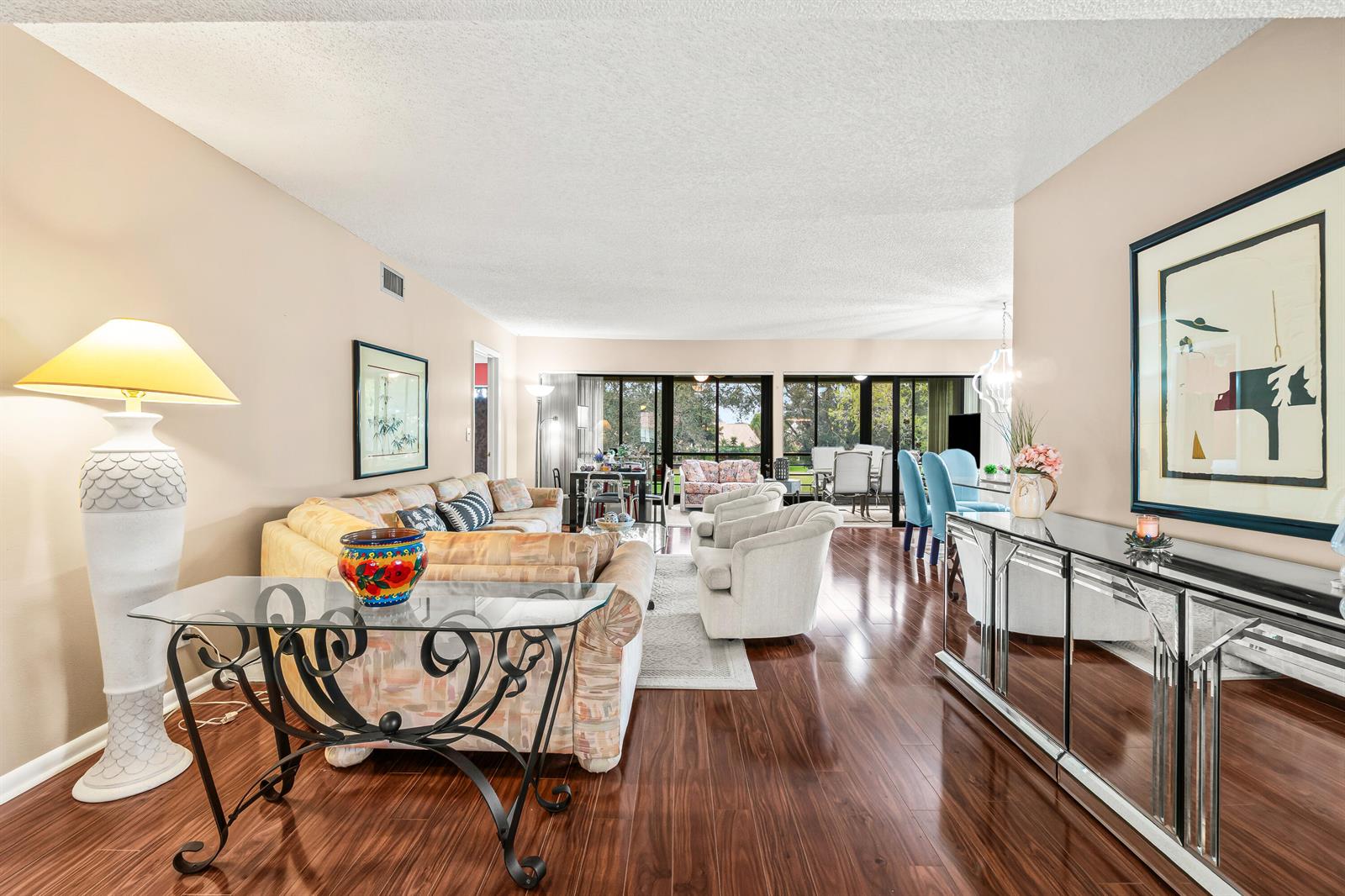 A living room features hardwood floors, a glass console table, and a large sectional sofa — 5687 Fairway Park Drive, Boynton Beach FL 33437, BOYNTON BEACH, FL