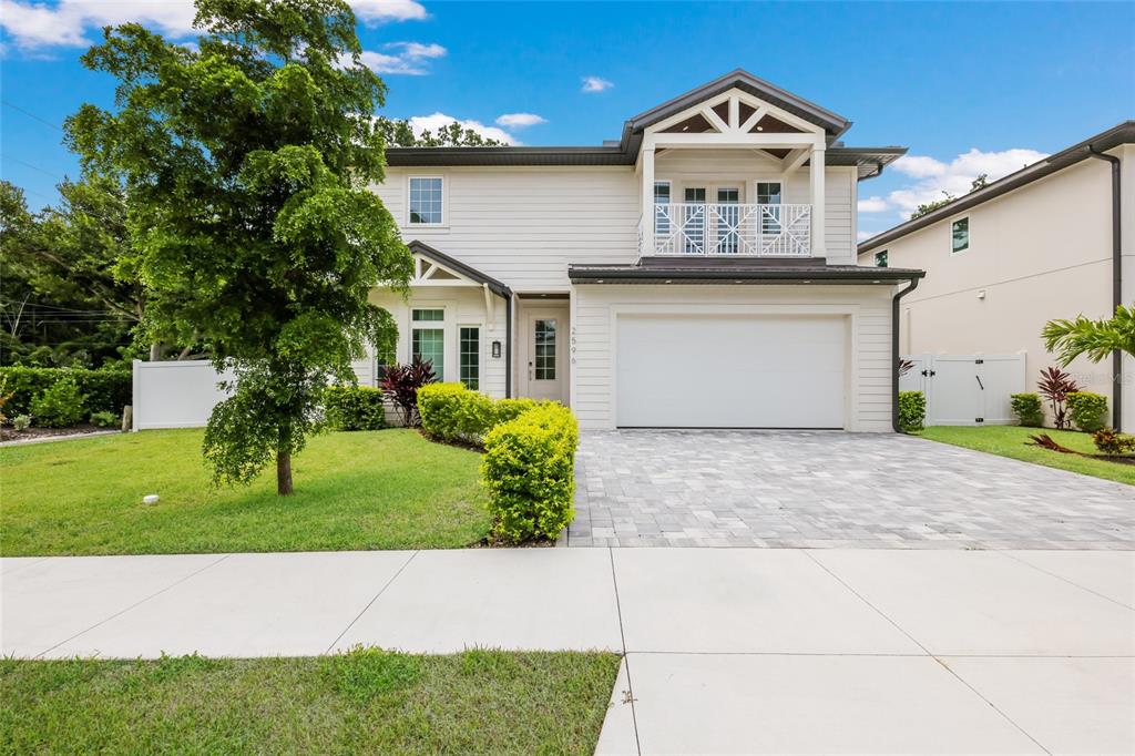 A two-story house with white horizontal siding, a two-car garage, and a second-story balcony — 2596 FLOYD STREET, SARASOTA, FL