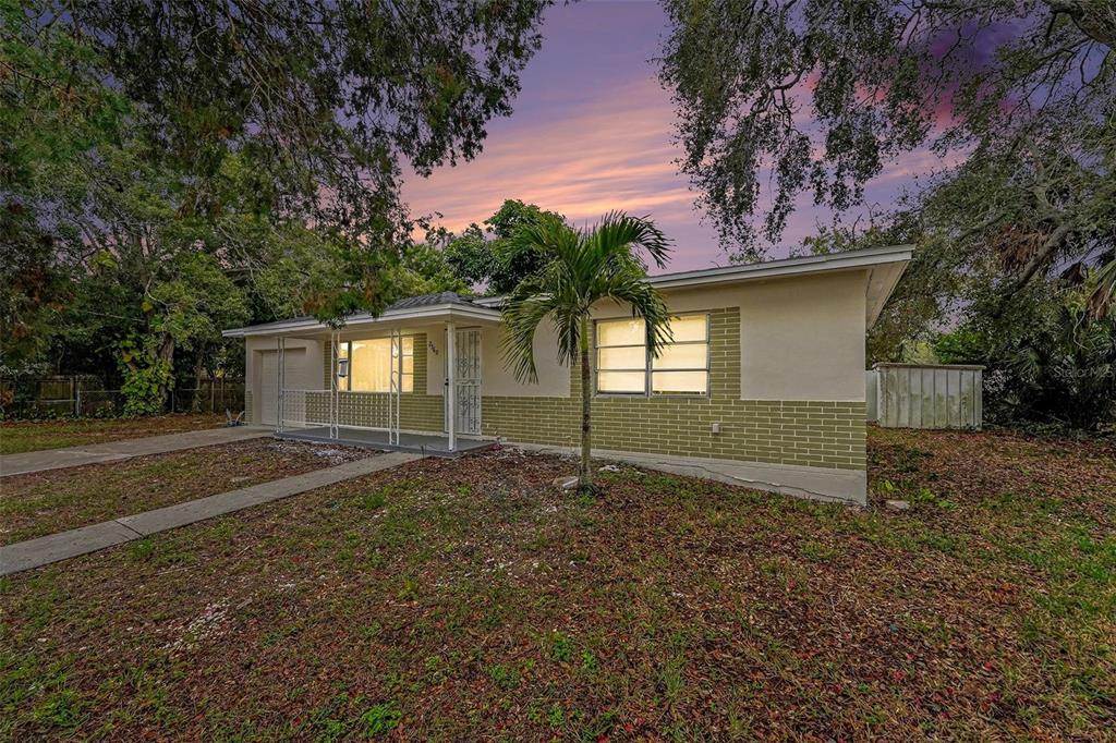 A single-story house with a brick facade, a palm tree, and a concrete driveway — 2560 QUEENSBORO AVENUE S, ST PETERSBURG, FL