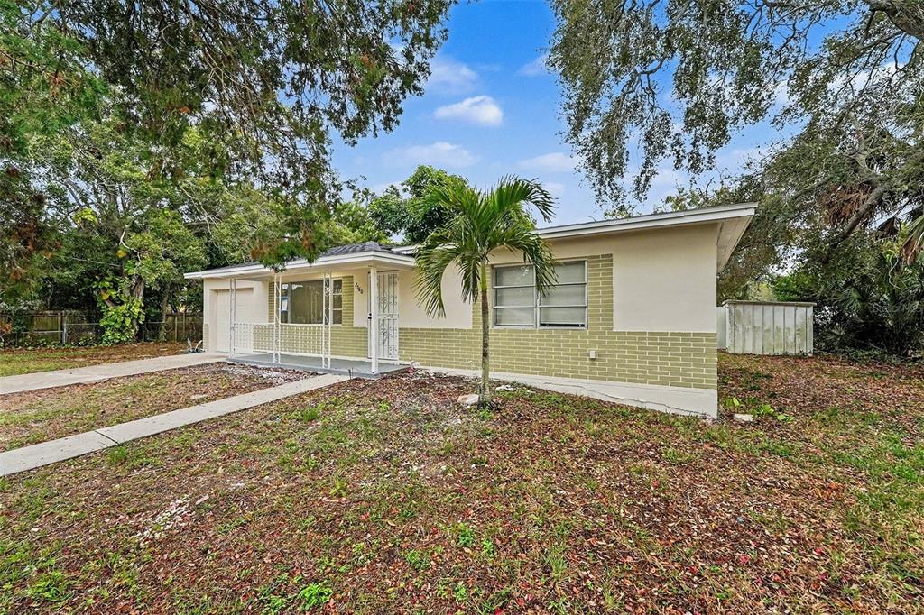 A single-story house with a light-colored facade, brick base, and a small palm tree — 2560 QUEENSBORO AVENUE S, ST PETERSBURG, FL