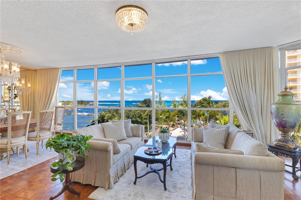 A living room with two sofas, a coffee table, and floor-to-ceiling windows overlooking the ocean — 800 ASHFORD AVENUE UNIT 6-B, SAN JUAN, PR
