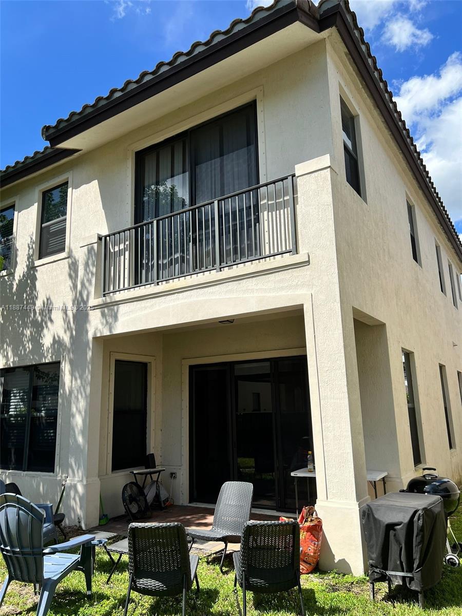 The exterior of a two-story house features a balcony, a patio, and a backyard — 3214 W 97th St, Hialeah FL 33018, HIALEAH, FL