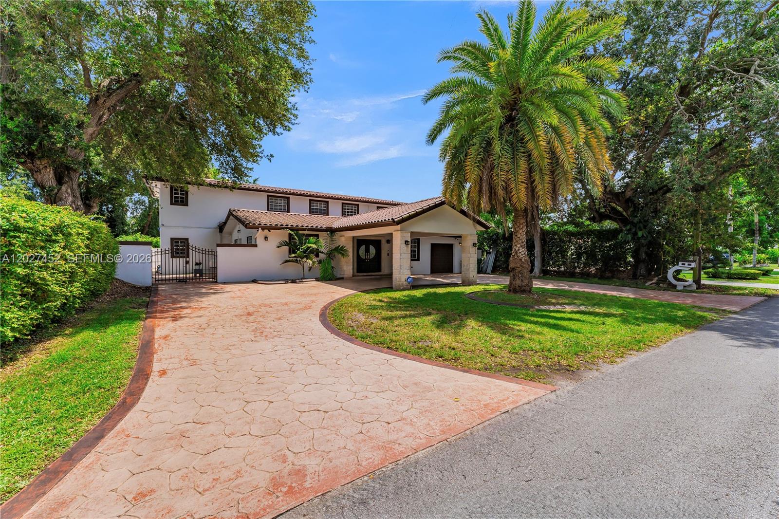 A two-story white house features a curved driveway, a palm tree, and a covered entryway — 6284 SW 26th St, Miami FL 33155, MIAMI, FL