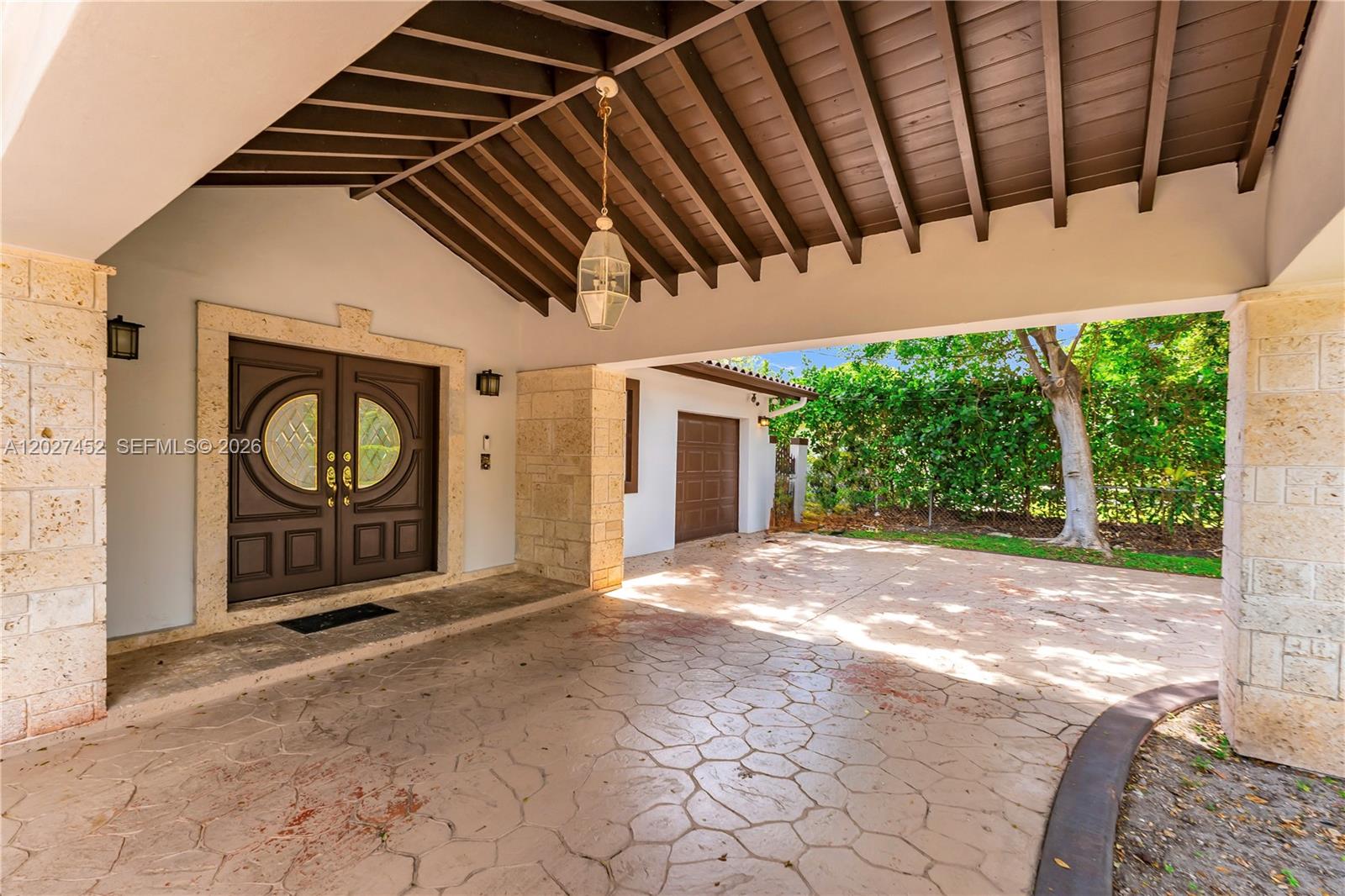 A covered entryway features a stone-trimmed double door, a hanging lantern, and a stamped concrete floor — 6284 SW 26th St, Miami FL 33155, MIAMI, FL