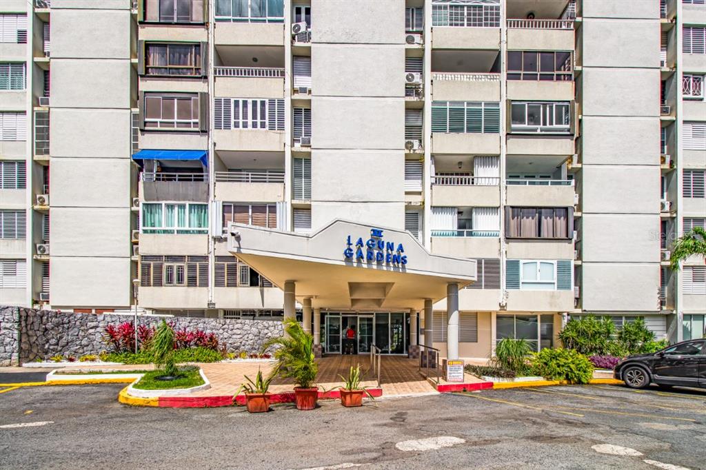 The exterior of a multi-story apartment building with a covered entrance and parking area — 2 COND LAGUNA GARDENS II UNIT 9A, CAROLINA, PR