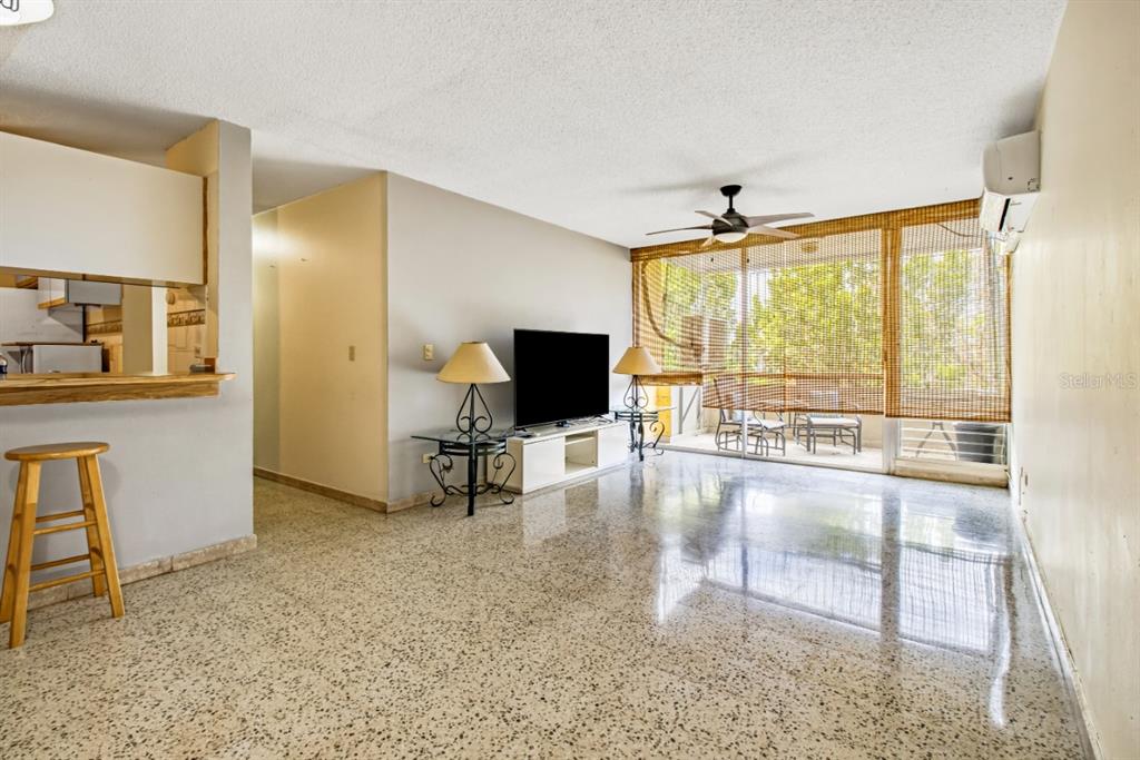 A living room with terrazzo floors, a ceiling fan, and a balcony with bamboo shades — 2 COND LAGUNA GARDENS II UNIT 9A, CAROLINA, PR