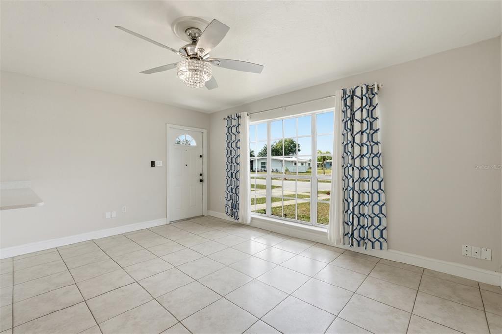 A bright room with light tile flooring, a ceiling fan, and a large window — 21882 HAINES, PORT CHARLOTTE, FL