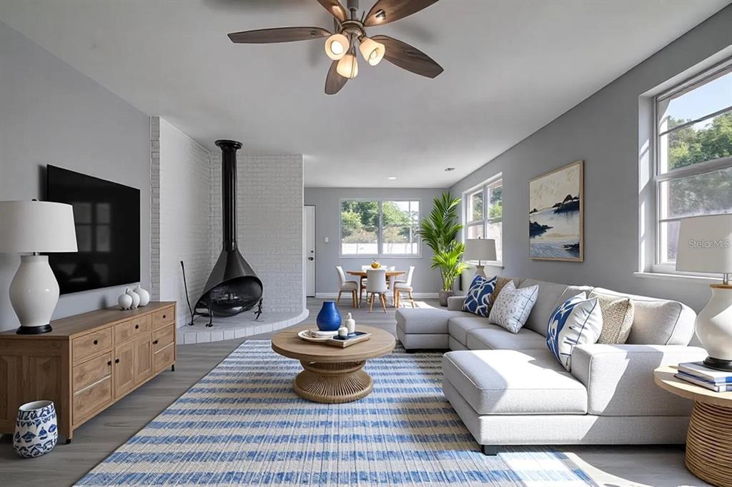 A living room features a modern fireplace, a sectional sofa, and a blue-striped area rug — 2107 MONTICELLO AVENUE, LAKELAND, FL