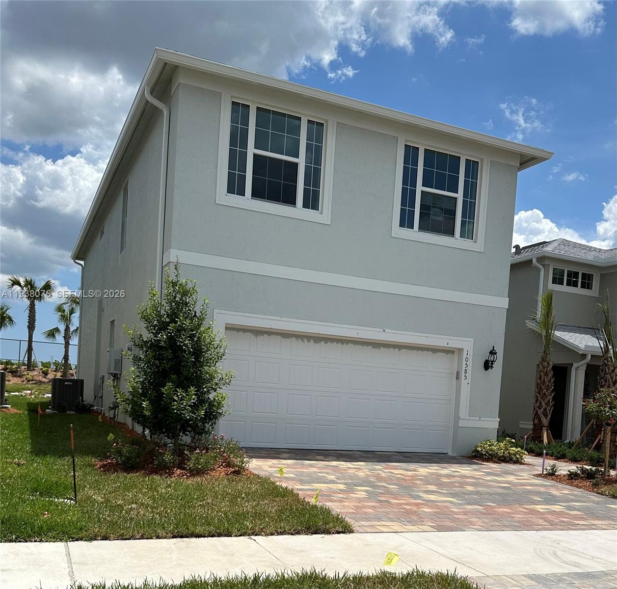 A two-story house with a light gray exterior, a two-car garage, and a paved driveway — PORT ST. LUCIE, FL