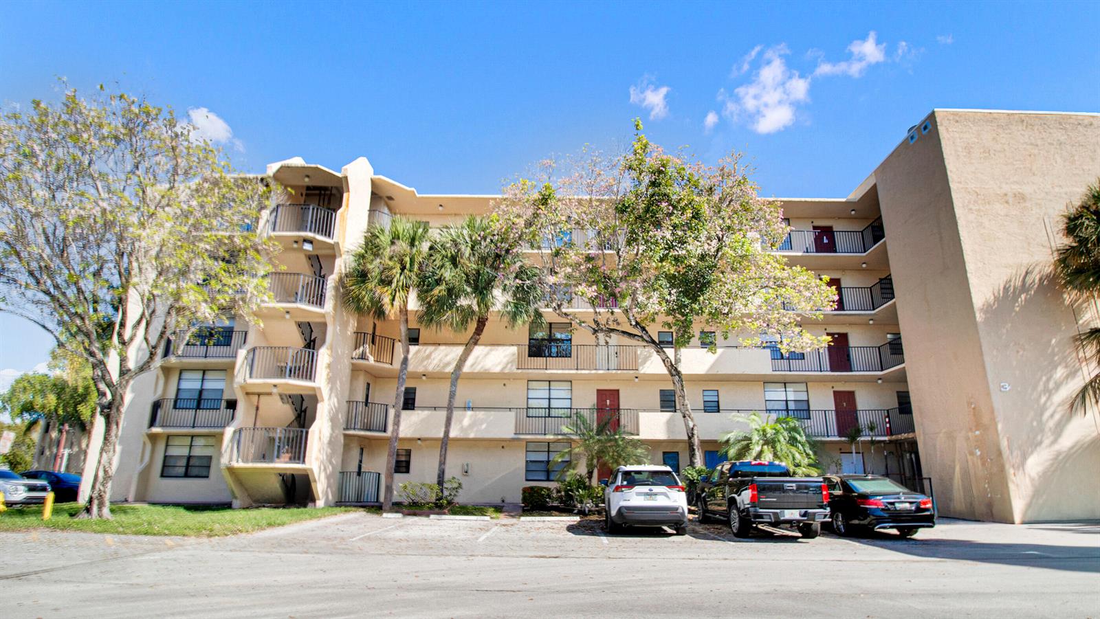 A multi-story apartment building with balconies and a parking lot in front — 3450 Blue Lake Drive # 305, Pompano Beach FL 33064, POMPANO BEACH, FL