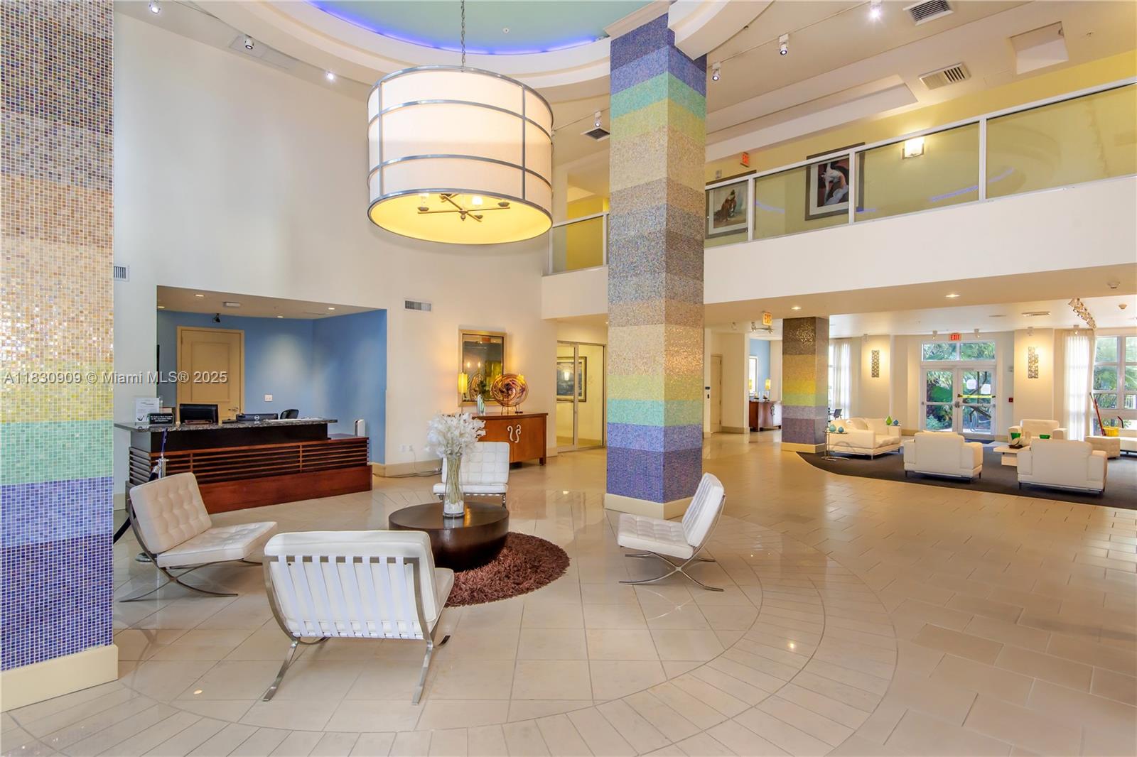 A spacious, modern lobby features tiled columns, white leather chairs, and a large drum chandelier — 2000 N Bayshore Dr # 509, Miami FL 33137, MIAMI, FL