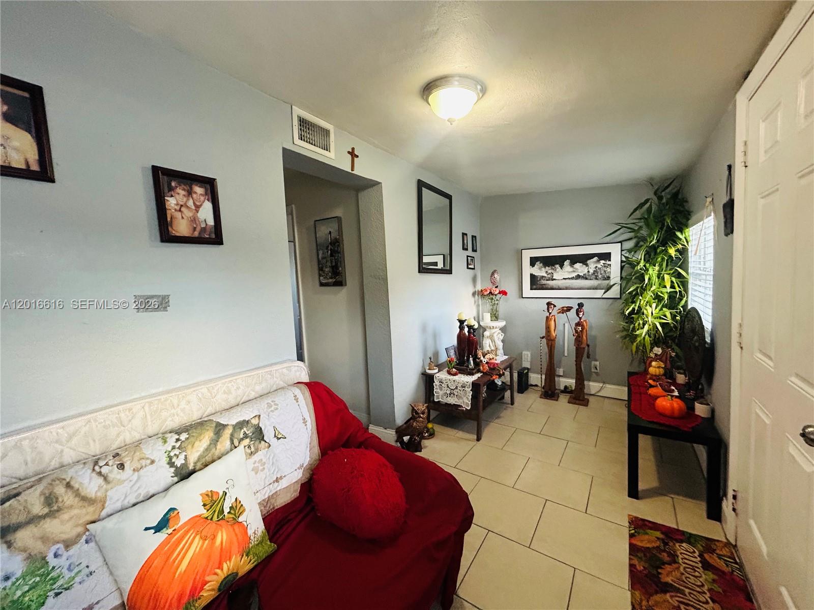 A living room features light blue walls, tile flooring, a red sofa, and decorative accents — 244 SW 36th Ave, Miami FL 33135, MIAMI, FL