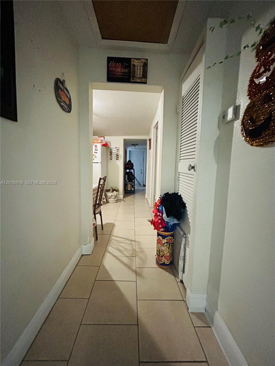 A tiled hallway leads from the foreground toward a kitchen and a distant doorway — 244 SW 36th Ave, Miami FL 33135, MIAMI, FL