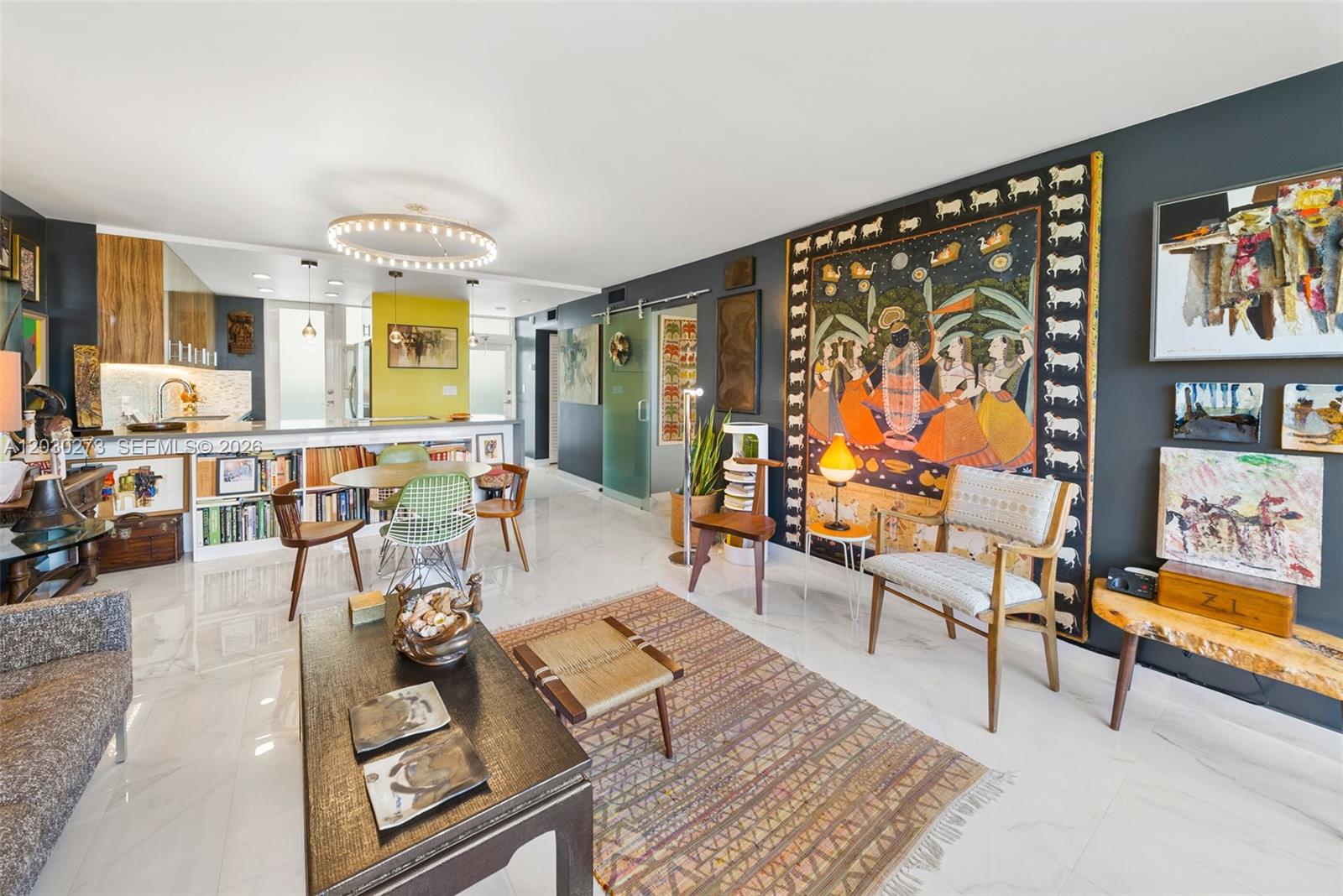 A living room with white marble floors, a large wall tapestry, and an open kitchen — 1670 Lincoln Ct # 2B, Miami Beach FL 33139, MIAMI BEACH, FL