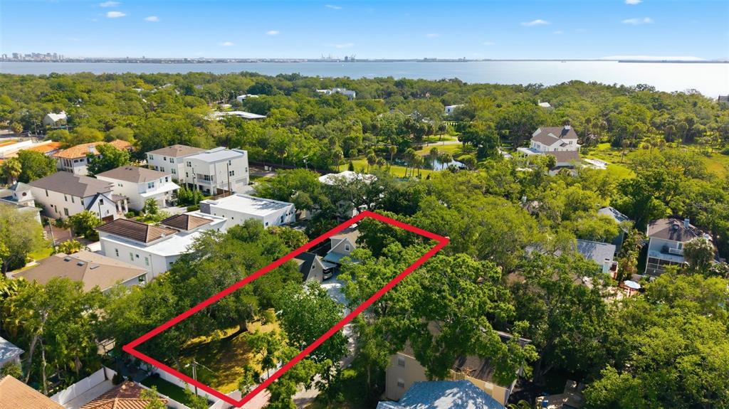 An aerial view shows a rectangular residential lot outlined in red amidst a wooded neighborhood — 2607 W WYOMING AVENUE, TAMPA, FL