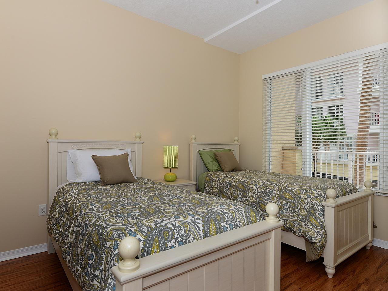 A bedroom with two twin beds, paisley bedding, a nightstand, and a window with blinds — 1200 Town Center Drive # 216, Jupiter FL 33458, JUPITER, FL