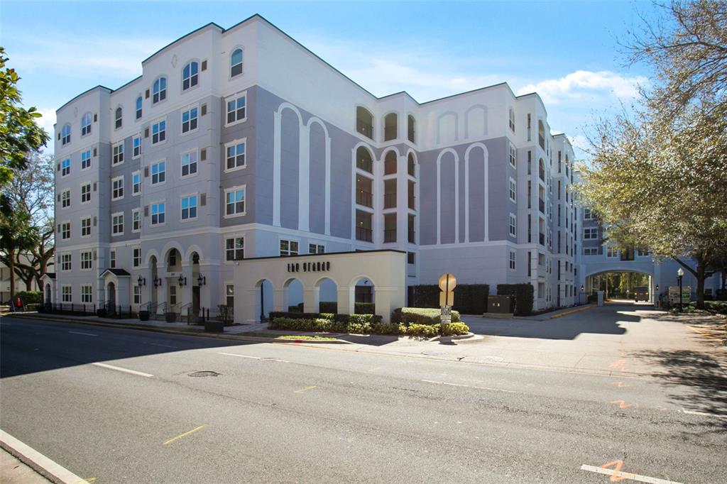 A multi-story apartment building with a light-colored facade and an arched entrance sign — 204 E SOUTH STREET UNIT 6057, ORLANDO, FL