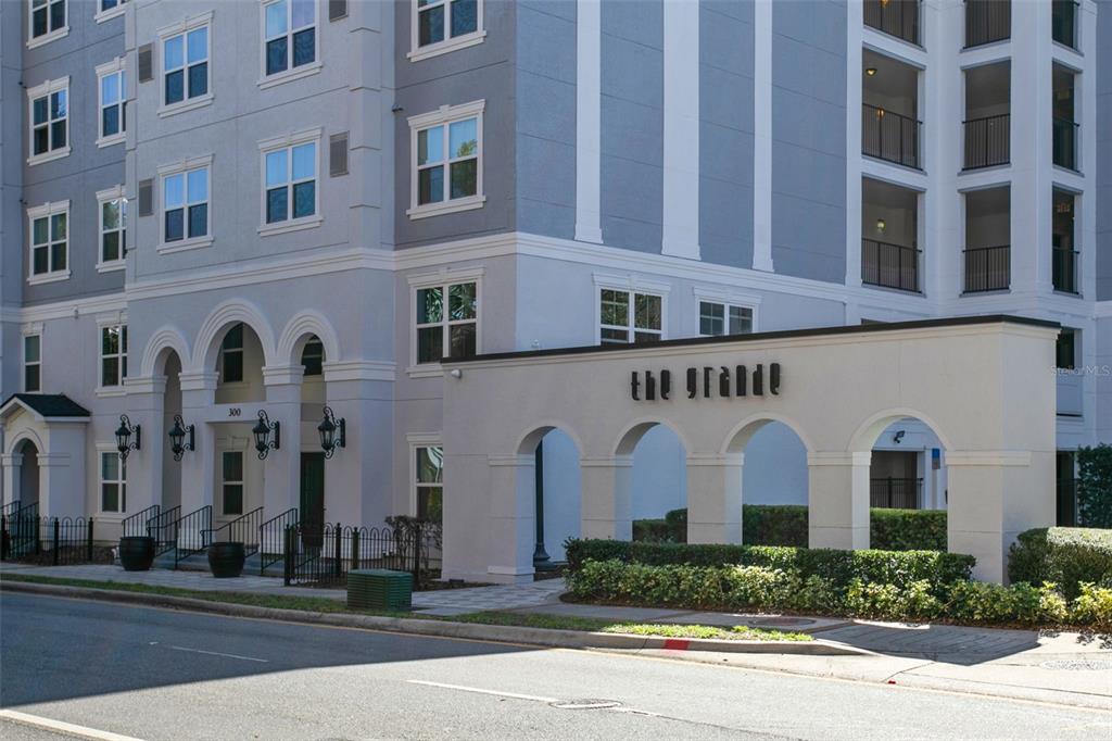 A multi-story apartment building with a gray and white facade at dusk — 204 E SOUTH STREET UNIT 6057, ORLANDO, FL