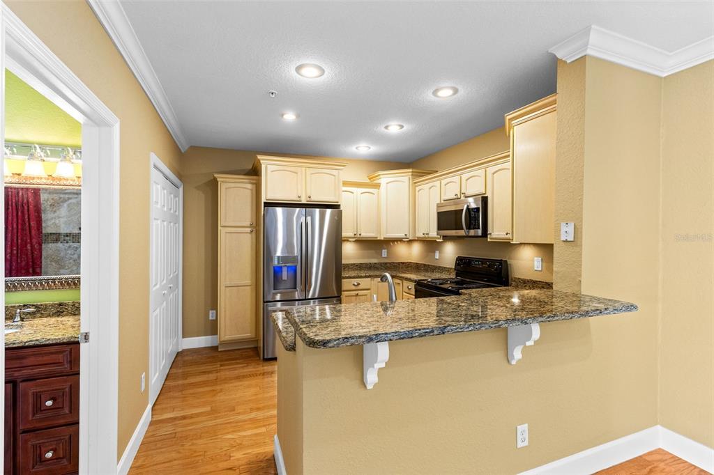 An open-concept living area with hardwood floors, a kitchen breakfast bar, and French doors — 204 E SOUTH STREET UNIT 6057, ORLANDO, FL