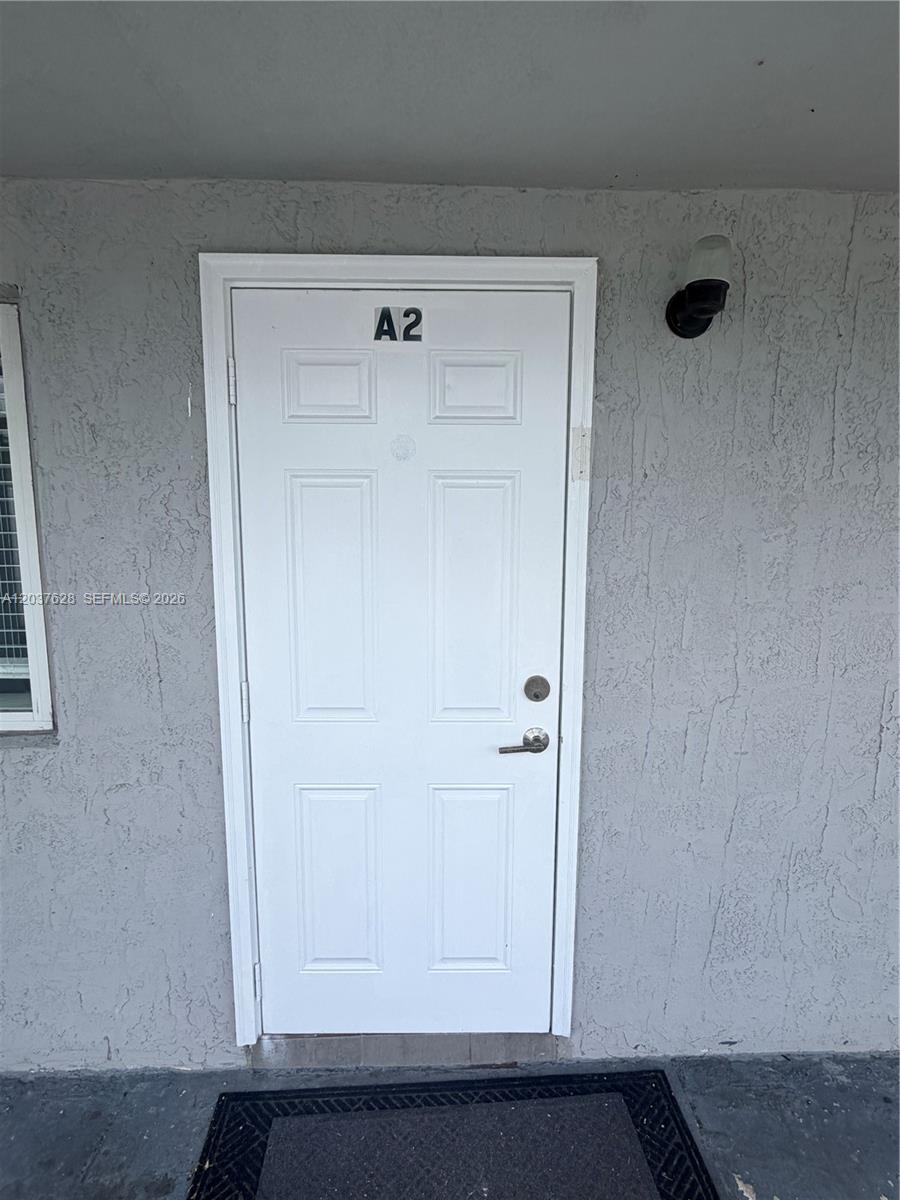 A white front door labeled A2 is set into a textured gray exterior wall — 1315 N 22nd Ave # A2, Hollywood FL 33020, HOLLYWOOD, FL