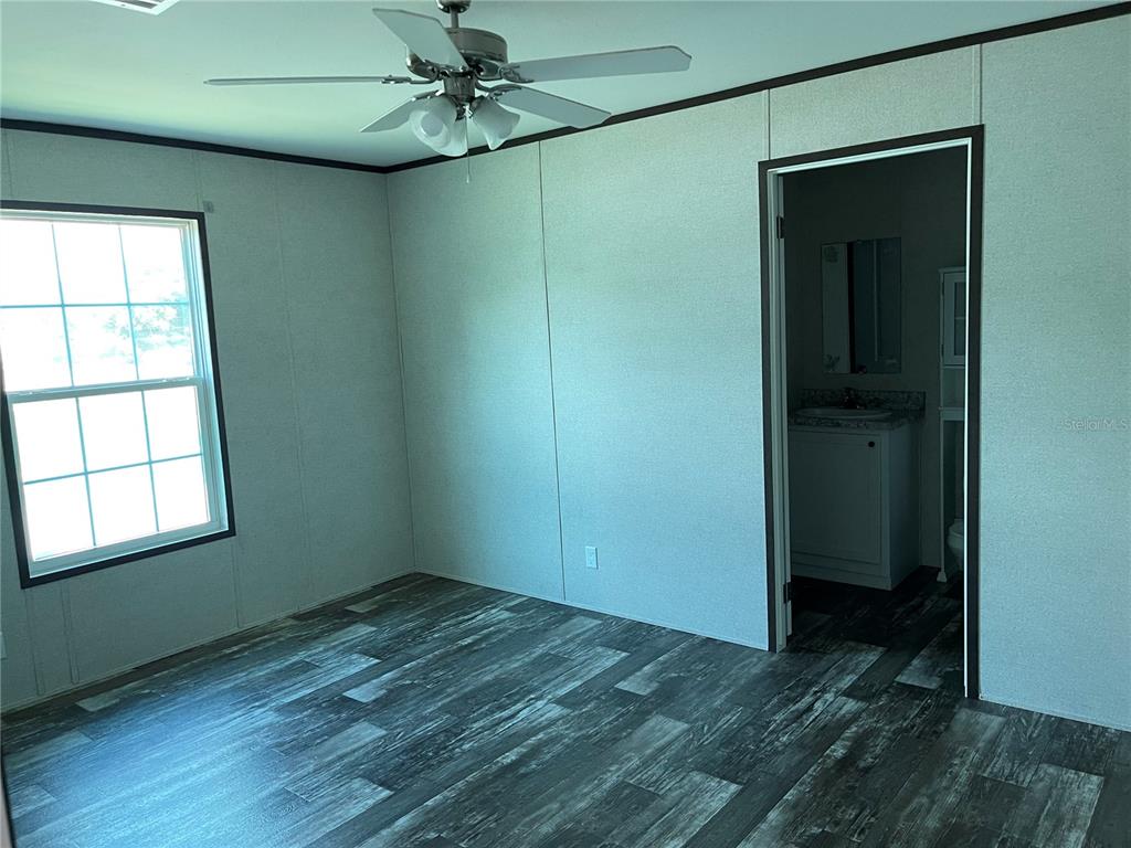 A bedroom with light-colored walls, a ceiling fan, a window, and wood-look flooring — 6964 POMPEII ROAD, ORLANDO, FL