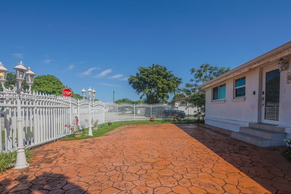 A white house with a stamped concrete driveway and a white metal fence — 3495 W 2nd Ave, Hialeah FL 33012, HIALEAH, FL