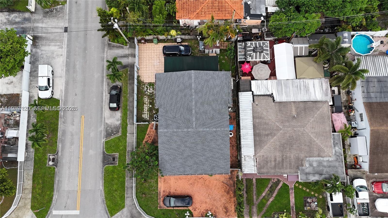 An aerial view shows a residential property with a gray roof, driveway, and surrounding houses — 3495 W 2nd Ave, Hialeah FL 33012, HIALEAH, FL