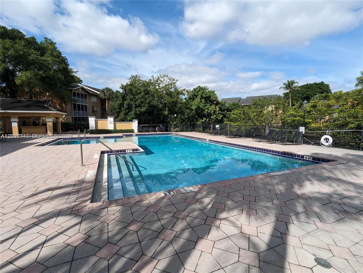 A rectangular outdoor swimming pool with a paved deck and lounge chairs — 4055 W Mcnab Rd # H112, Pompano Beach FL 33069, POMPANO BEACH, FL