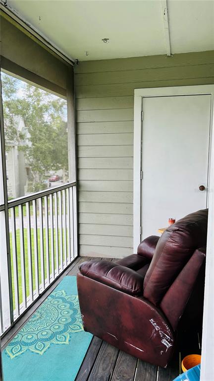 A screened-in balcony features a dark leather recliner, a teal patterned rug, and white railings — 6010 WESTGATE DRIVE UNIT 303, ORLANDO, FL