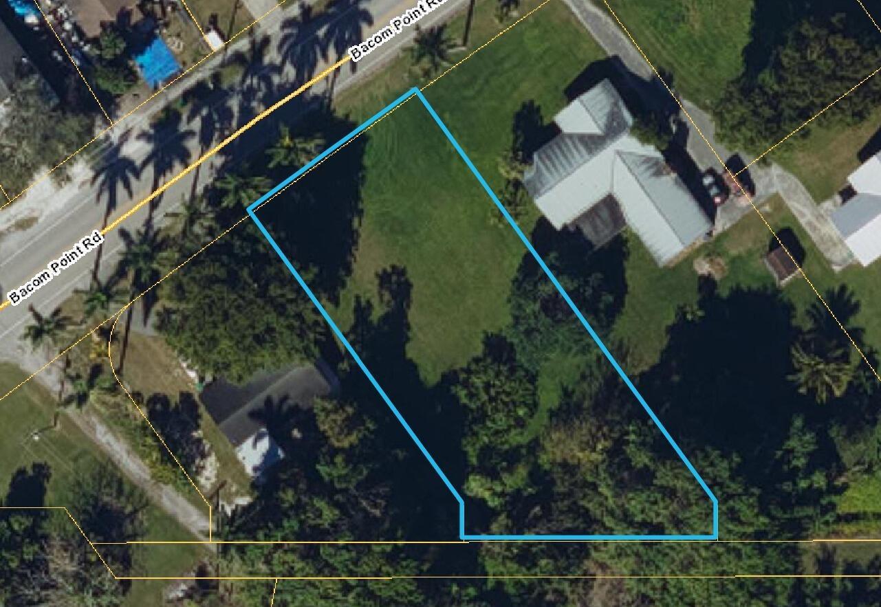 An aerial view of a vacant, irregularly shaped residential lot outlined in blue — 00 Bacom Point Road, Pahokee FL 33476, PAHOKEE, FL