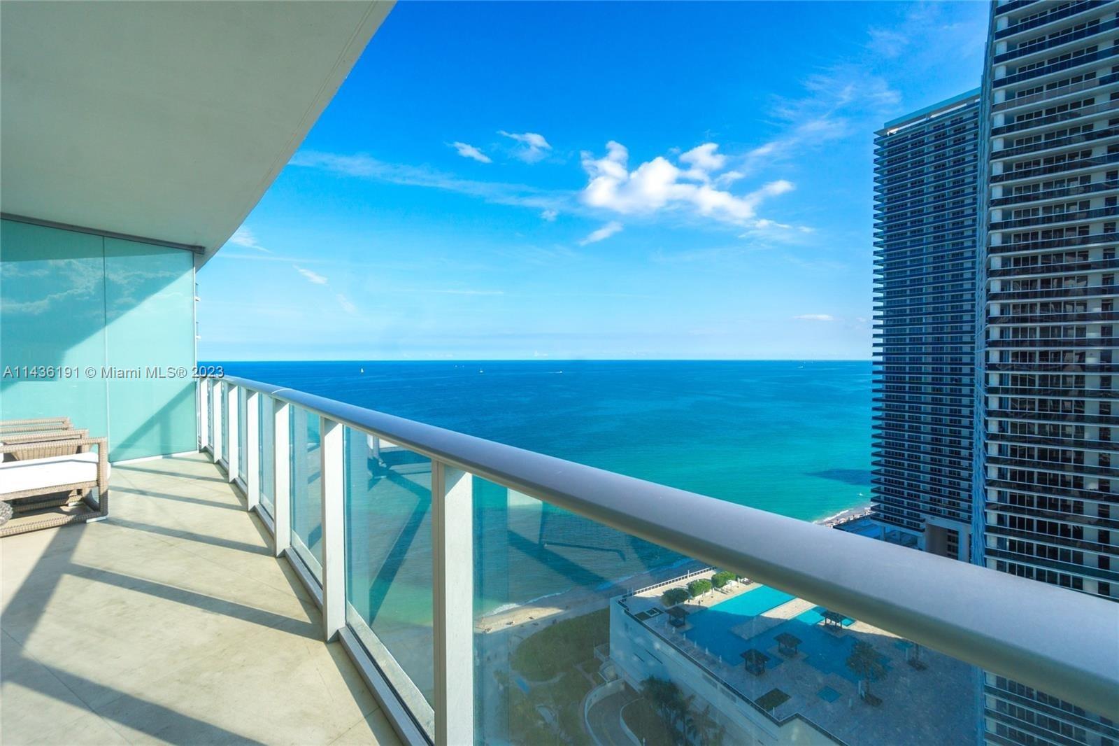 A high-rise balcony overlooks the ocean, a beach, and a swimming pool below — 4111 S Ocean Dr # 2307, Hollywood FL 33019, HOLLYWOOD, FL