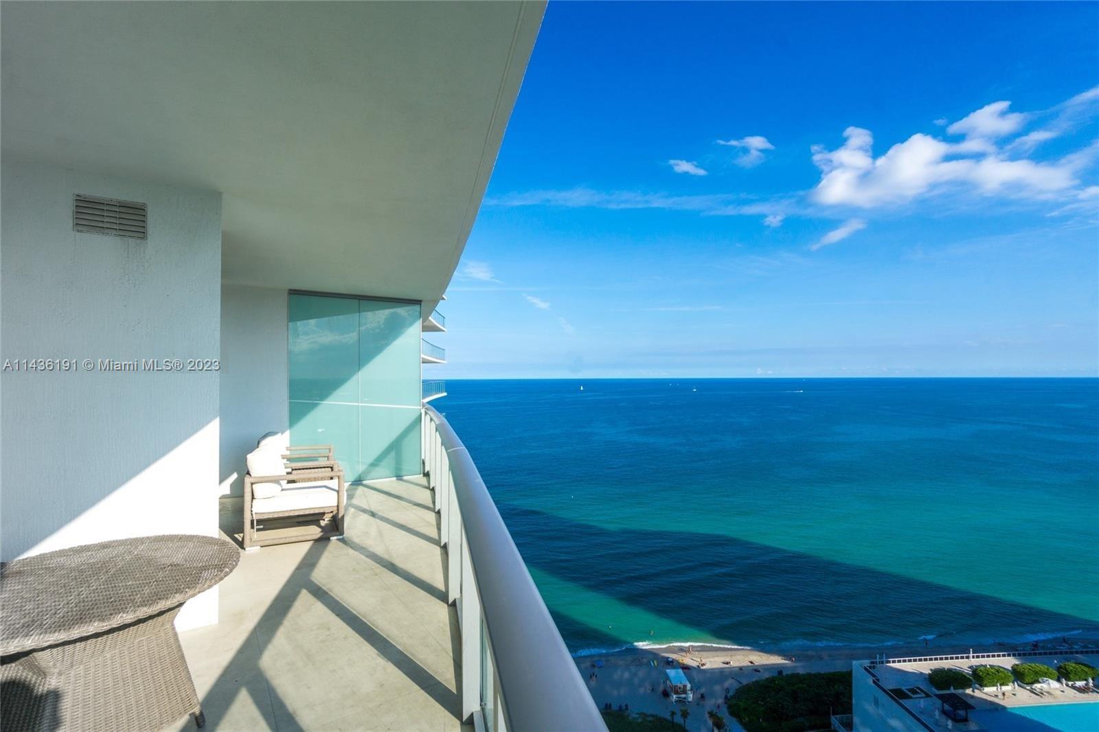 A high-rise balcony overlooks the ocean with a small table and chair set — 4111 S Ocean Dr # 2307, Hollywood FL 33019, HOLLYWOOD, FL