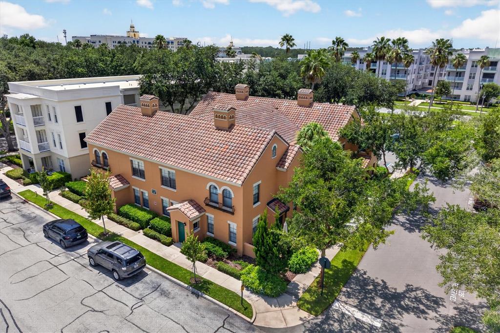 An aerial view shows a two-story orange stucco building with a tiled roof — 730 SIENA PALM DRIVE UNIT 104, CELEBRATION, FL